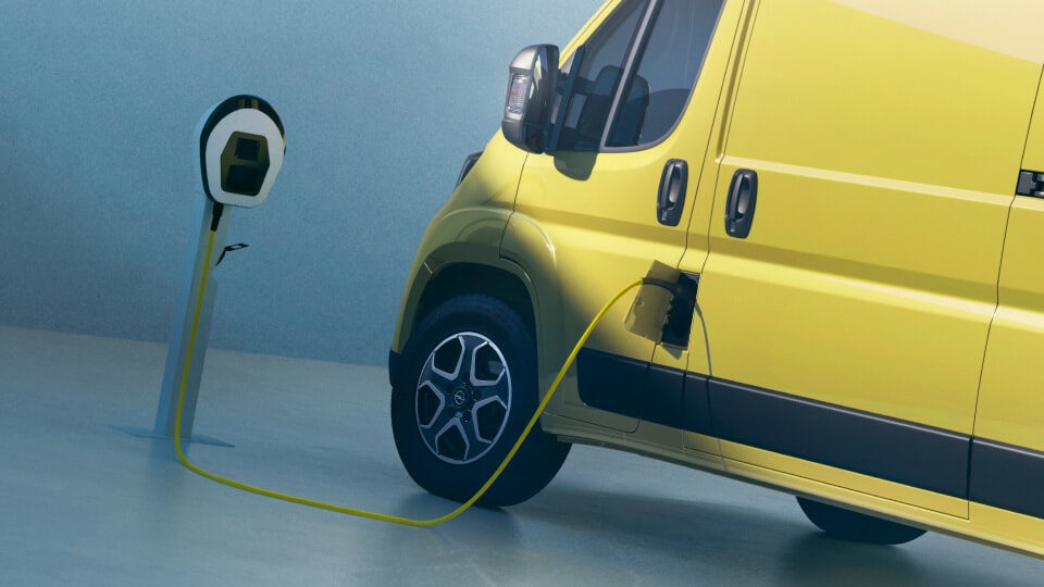 Seitenansicht eines gelben Opel Elektro-Vans beim Laden an einer Ladestation.