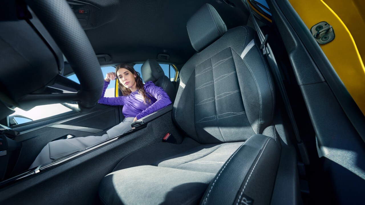 Black front seats of an Opel Astra Electric with woman sitting in passenger seat
